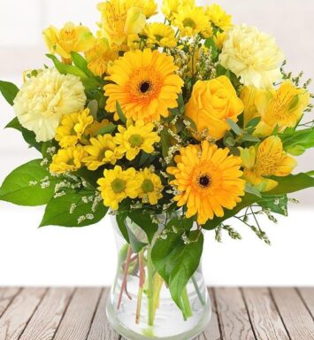 a bouquet of yellow flowers in a glass vase