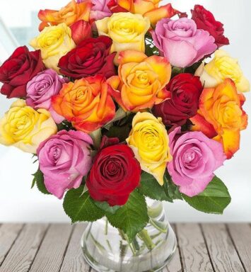 a bouquet of colorful roses in a glass vase