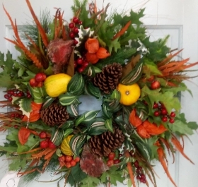 a wreath with fruits and vegetables on a door